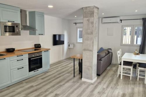 a kitchen and living room with a couch and a table at La casita de Lucentum in Alicante