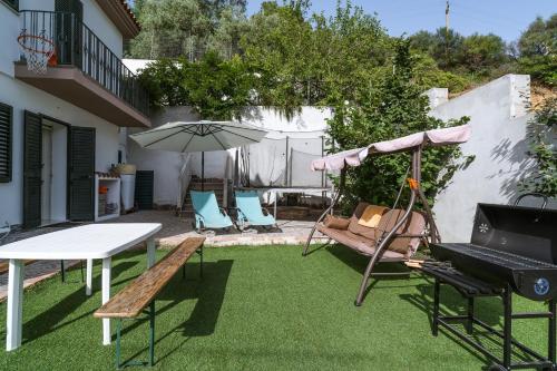 a patio with a table and chairs and an umbrella at Domo de Ro' in Onifai