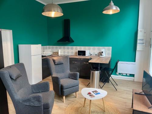 - une cuisine avec des murs verts, 2 chaises et une table dans l'établissement Résidence Pont à l'Herbe, à Douai