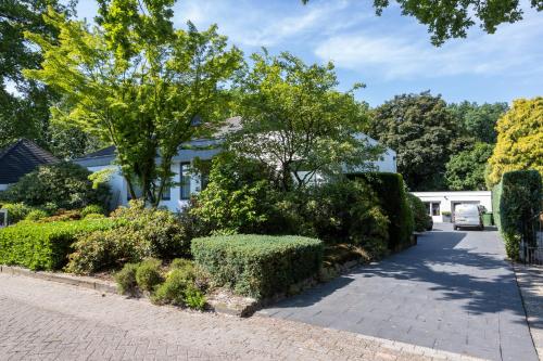 a white house with a driveway at B&B Eikendreef in Haelen