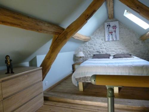 een slaapkamer met een bed op zolder bij Les volets rouges in Sémoy