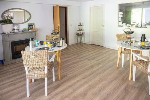 a living room with two tables and chairs and a fireplace at B&B Eikendreef in Haelen