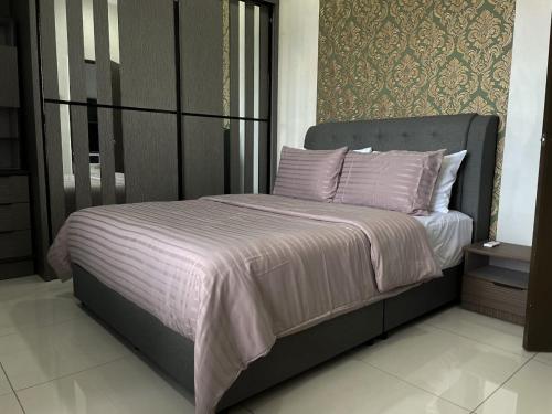 1 dormitorio con 1 cama grande con sábanas y almohadas rosas en Sg Buloh Cozy Apartment WiFi & Netflix (Rahman Putra) (6pax), en Sungai Buloh