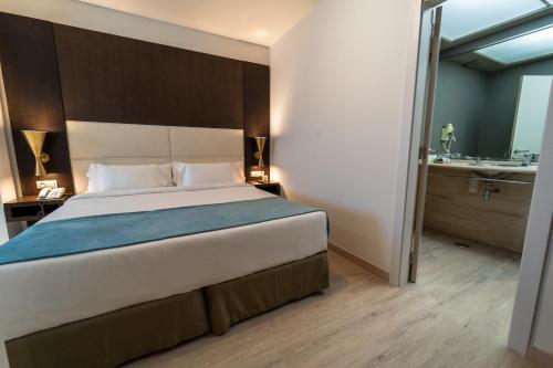 a bedroom with a large bed and a bathroom at Hotel Taburiente S.C.Tenerife in Santa Cruz de Tenerife