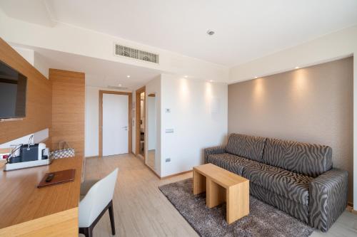 a living room with a couch and a table at Laguna Park Hotel 4Superior in Bibione
