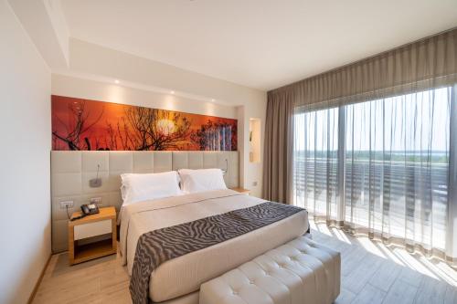 a hotel room with a bed and a large window at Laguna Park Hotel 4Superior in Bibione