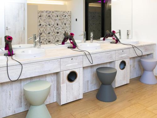 a bathroom with two sinks and two toilets at Hotel Plumm in Yokohama