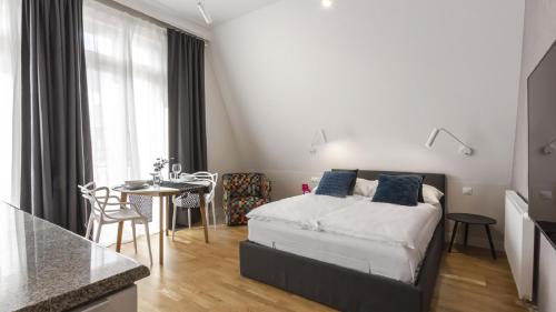 Un pequeño dormitorio con una cama y una mesa. en Wisus - Luxury Apartments, en Świnoujście