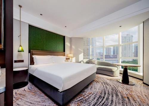 1 dormitorio con 1 cama blanca grande y ventana grande en Shenzhen Shanghai Hotel -Complimentary Mini Bar and Late Check Out en Shenzhen