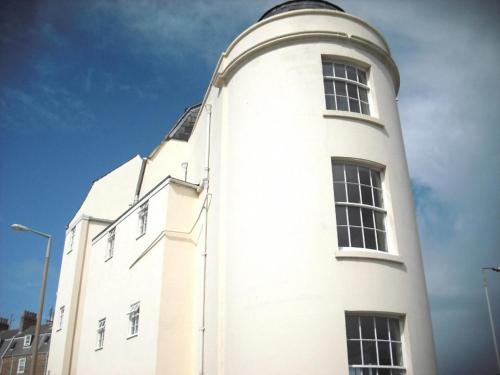 a tall white building with windows on top of it at The Roundhouse in Weymouth