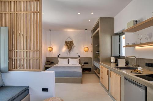 a small bedroom with a bed and a kitchen at Clementina Paros in Naousa
