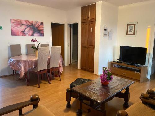 a living room with a table and a television at Apartments Pende in Rab