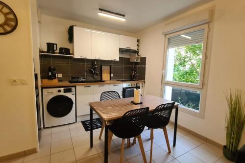 a kitchen with a table and chairs in a kitchen at Appt 2 pièces paisible : Confort & Parking inclus! in Savigny-le-Temple