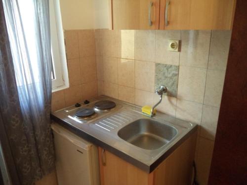 a small kitchen with a sink and a window at Vito Apartments Sutomore in Sutomore