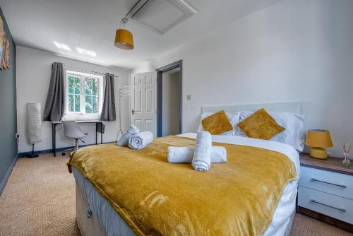 a bedroom with a large bed with yellow sheets and pillows at NEC Exhibitor Home, Stay near Birmingham Airport in Birmingham