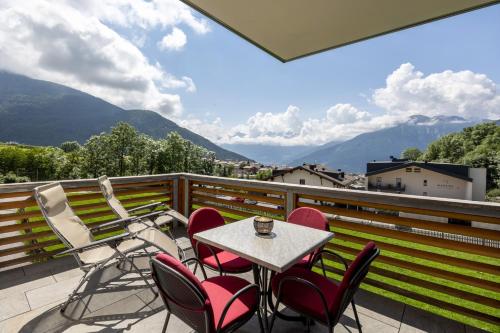 a table and chairs on a balcony with mountains at Maraias-Farm in Malles Venosta