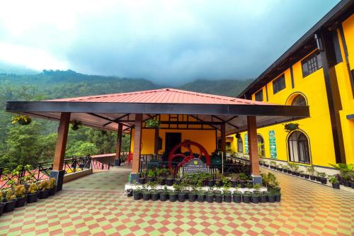 a yellow building with a pavilion in front of it at Mayfair Manor Jungpana in Darjeeling