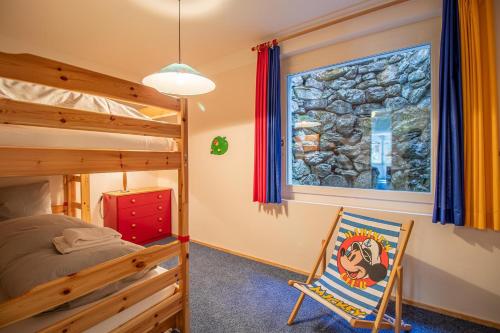 a bedroom with a bunk bed and a chair at Casa Cresta A31 in Arosa