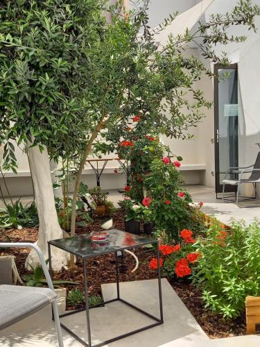 a table in front of a garden with flowers at Patio 101 "Exclusive" in San Vito lo Capo