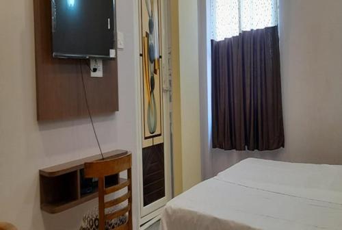 Cette chambre comprend un lit, une télévision et une fenêtre. dans l'établissement HOTEL SANJIBAN, à Māldah