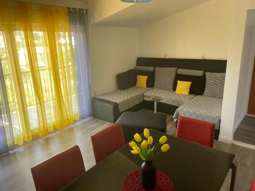 Sala de estar con cama y mesa con flores amarillas en Sweet apartment in quiet part of Split, en Split