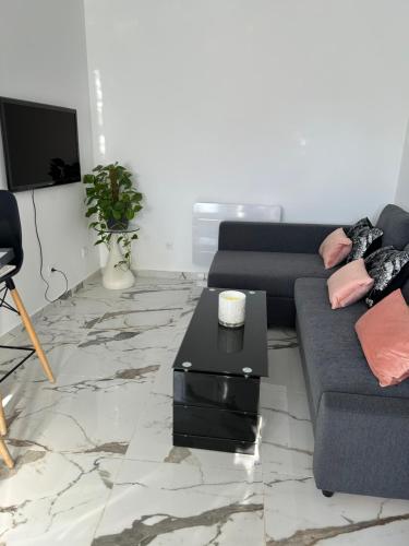 a living room with a couch and a coffee table at logement entier: suite chez Vanessa in Décines-Charpieu