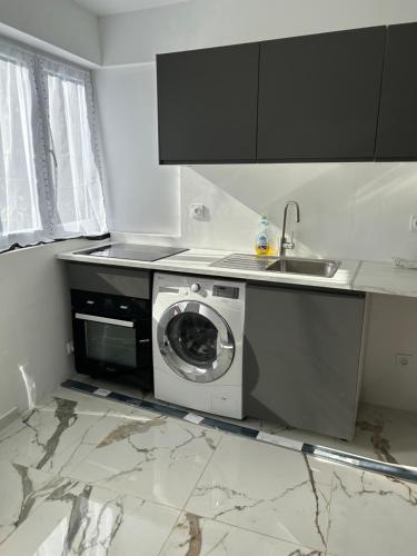 a kitchen with a washing machine and a sink at logement entier: suite chez Vanessa in Décines-Charpieu
