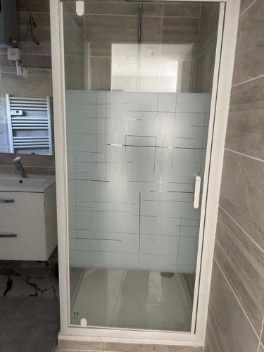 a shower with a glass door in a bathroom at logement entier: suite chez Vanessa in Décines-Charpieu