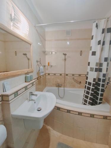 a bathroom with a sink and a bath tub at Olly Apartament PARKING i BALKON Ciechocinek in Ciechocinek