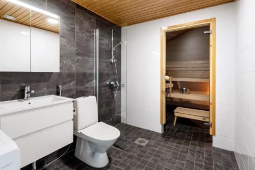 a bathroom with a toilet and a sink and a shower at Kotimaailma Apartments Loimu II with Private Sauna in Oulu