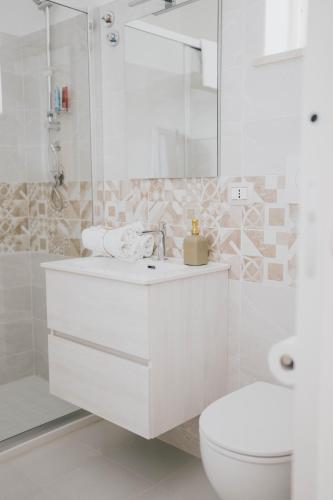 a white bathroom with a toilet and a sink at MAF B&B in Cupello