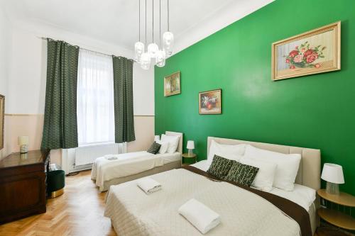 1 dormitorio con 2 camas y pared verde en Stunning Charles Bridge Apartment en Praga