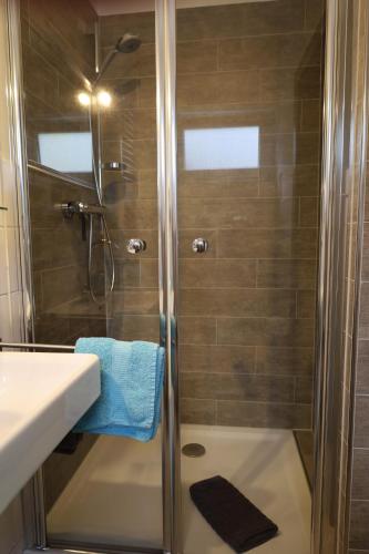 a shower with a glass door next to a sink at Weinburg -Das Ferienhaus in Cochem