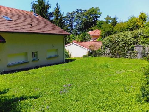 um quintal ao lado de uma casa com um relvado verde em Chambre à louer 15mnn de Grenoble-salle de bain privée-WIFI gratuit em Fontanil-Cornillon