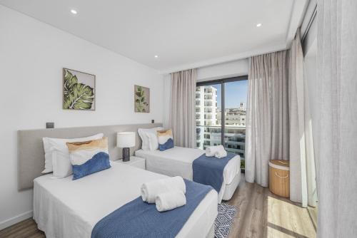 Habitación de hotel con 2 camas y ventana en Terraços de Quarteira Zen by Real Properties en Quarteira