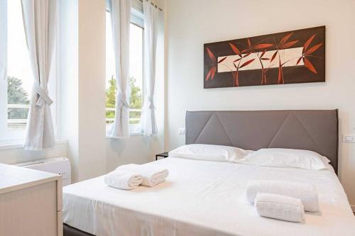 Un dormitorio con una cama blanca con toallas. en Living Fortezza 27! en Milán