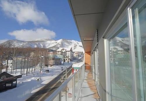 a balcony with a view of the snow covered mountains at The Setsumon in Kutchan