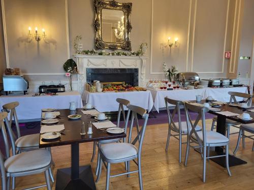 a dining room with tables and chairs and a fireplace at Leixlip Manor Hotel in Leixlip