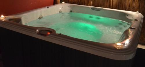 a bath tub filled with blue water with lights in it at Thornleigh House in Peterborough