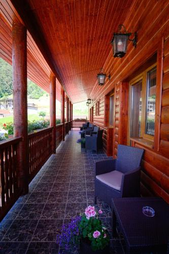 a porch of a building with chairs and flowers at Penzión Erika in Dedinky