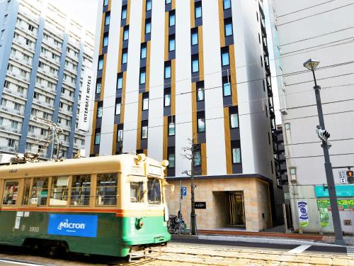 een tram op een straat voor een gebouw bij Hotel Intergate Hiroshima in Hiroshima