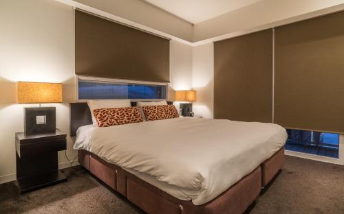 a bedroom with a large bed and two lamps at The Setsumon in Kutchan
