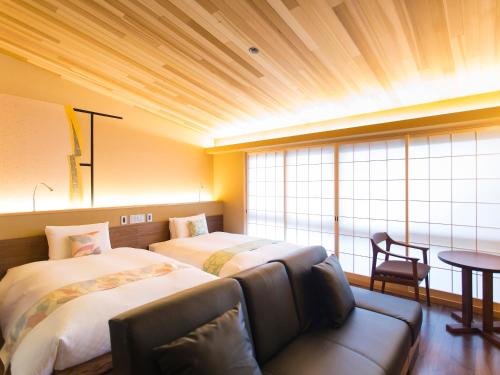 a hotel room with two beds and a couch at 枳殻の杜 Kikoku no mori in Kyoto