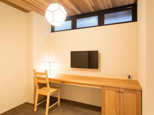 a room with a desk with a television and a chair at 枳殻の杜 Kikoku no mori in Kyoto