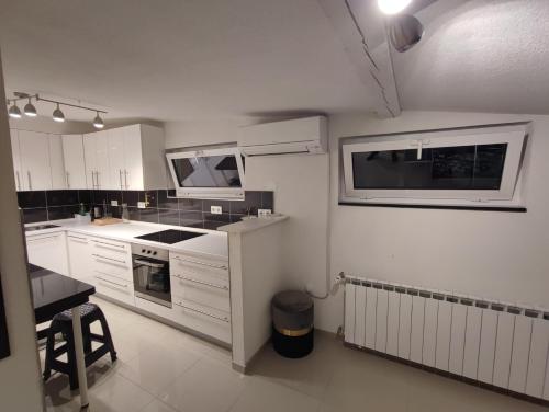 a kitchen with white cabinets and a microwave at APARTMANI VIJEĆNICA in Sarajevo