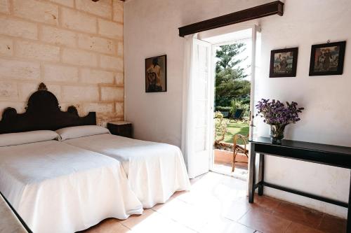 a bedroom with a bed and a table and a window at Agroturismo Son Triay in Ferreries