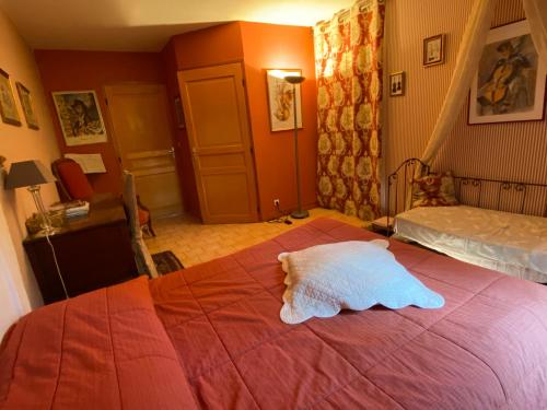 a bedroom with a bed with a white pillow on it at Chambres et Table d'Hôtes du Coquerel in Saint-Siméon
