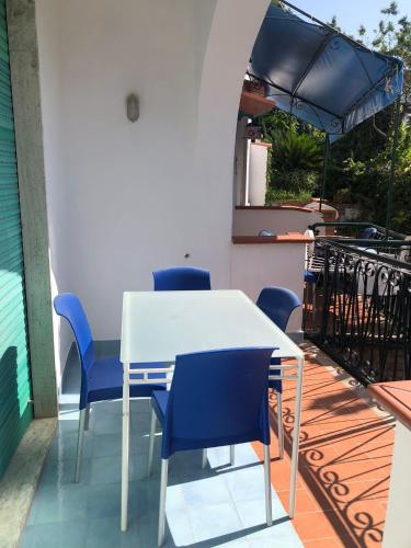 ヴィエトリにあるCasa Vacanze Teresaの白いテーブルと青い椅子付きのバルコニー