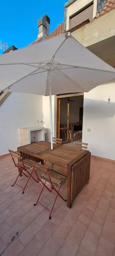 einen Tisch und Stühle unter einem Sonnenschirm auf einer Terrasse in der Unterkunft Casa Emma in Suvereto
