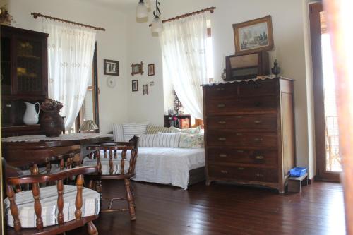 a bedroom with a bed and a dresser and a table at Malamo's home in Kissos